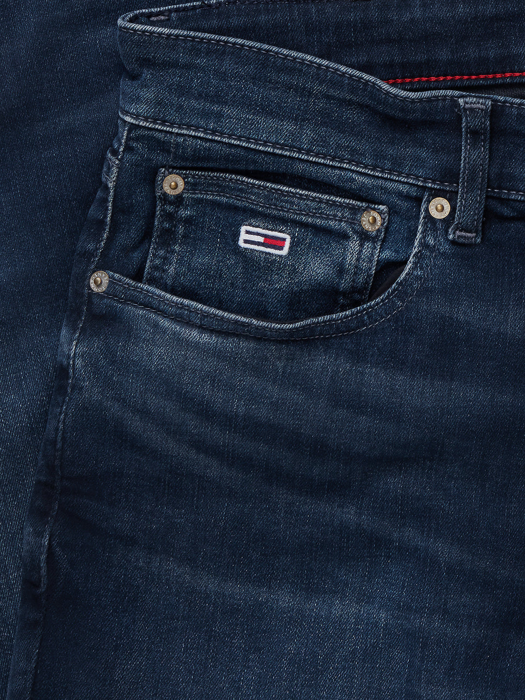 Dark blue denim jeans front coin pocket with small logo patch and metal buttons