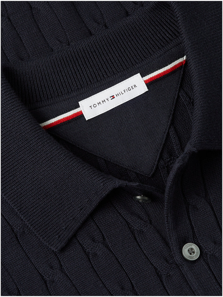 Navy polo collar close-up with TOMMY HILFIGER label and buttoned placket