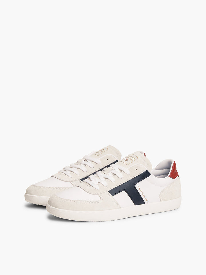 White low-top sneakers with navy side stripe and lace-up front