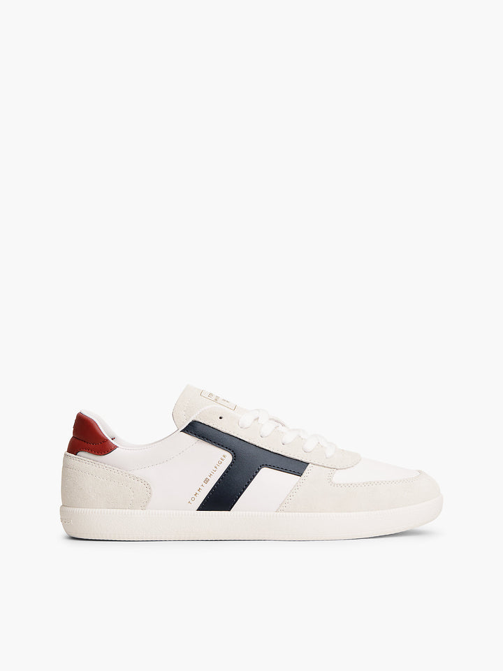 Cream and white low-top sneakers with navy side stripe and red heel tab