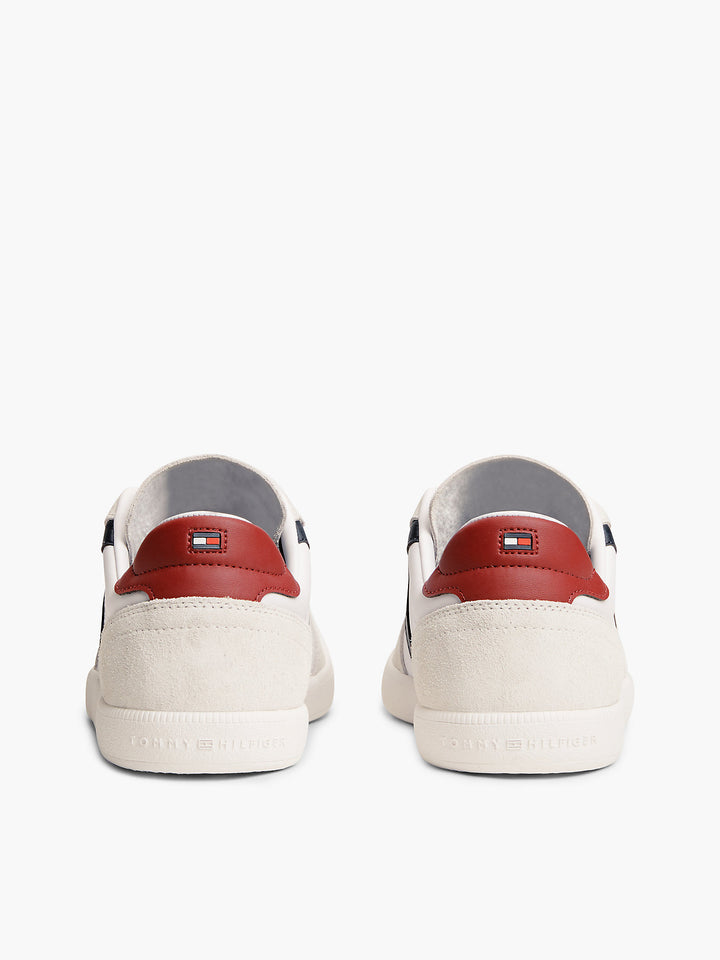 White low-top sneakers with red heel lining and rear logo detail