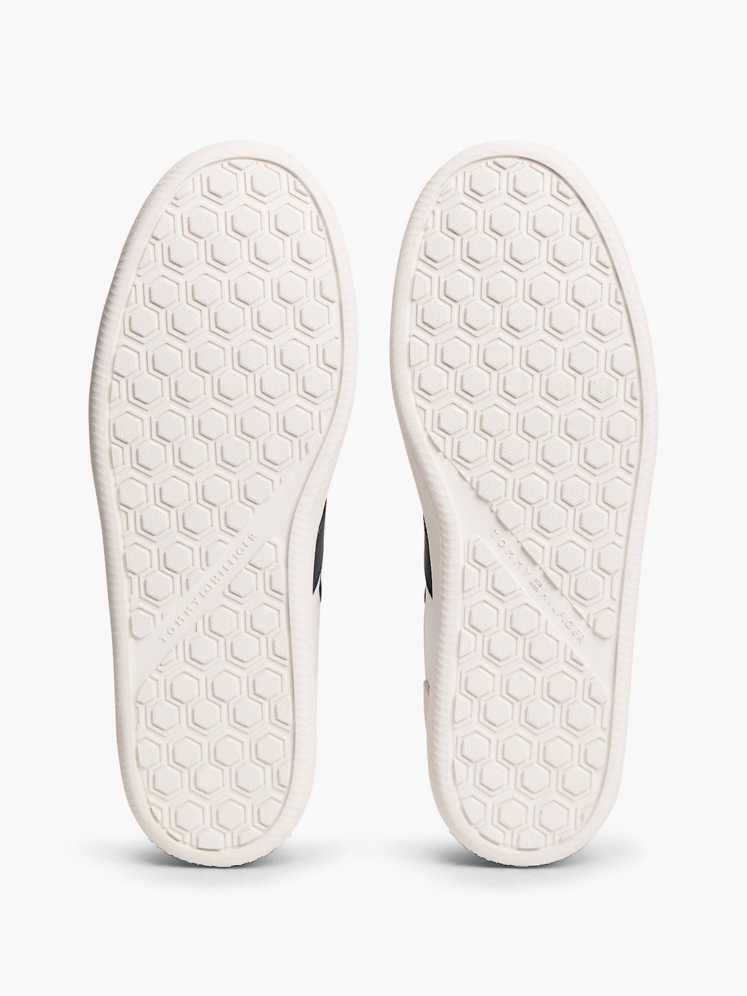 Pair of white sneaker outsoles with hexagon tread pattern