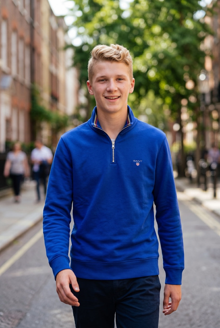 GANT blue half-zip sweatshirt on model, chest logo and long sleeves