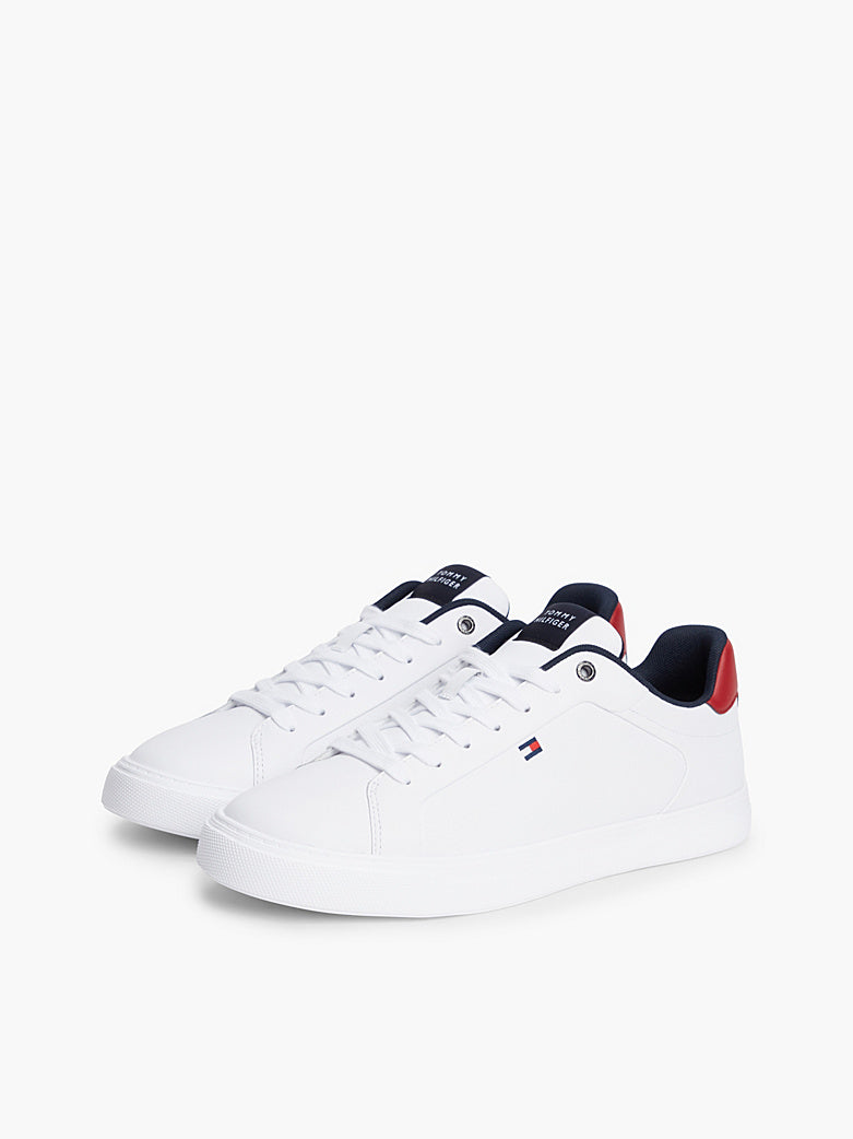 White low-top sneakers with navy collar and red heel tab, lace-up design.