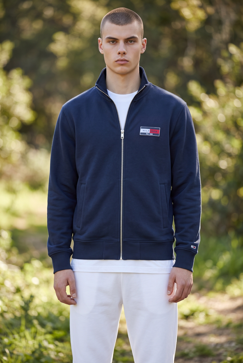 Men's navy zip sweatshirt on model, front zip and chest flag patch