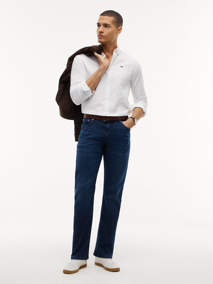 Dark blue slim-straight jeans on model with button waist and five-pocket styling