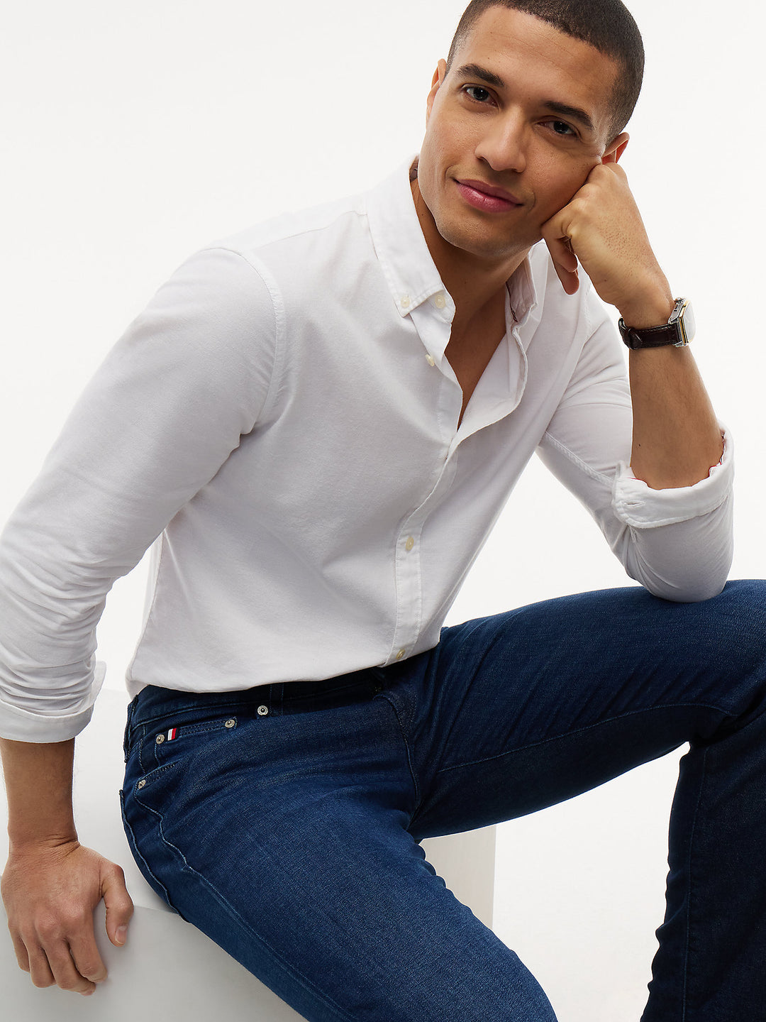 Dark blue denim slim-straight jeans, close-up of waistband, button, and front pockets