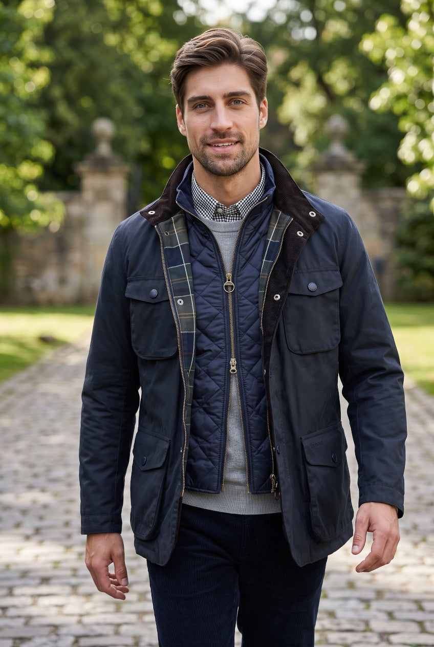 Men's Barbour navy waterproof jacket, zip front, snap pockets, quilted lining.
