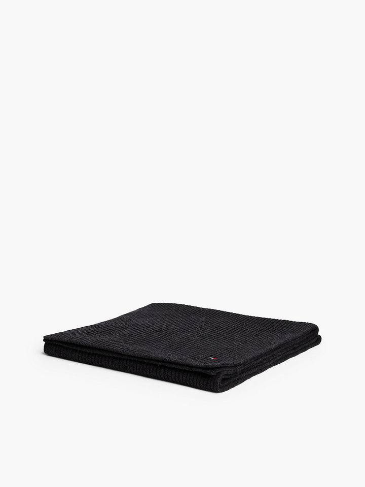 Folded dark knit scarf, ribbed texture with small flag logo