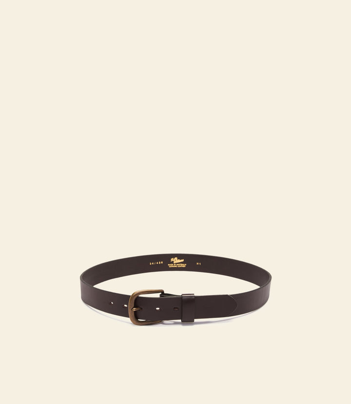 Brown leather belt with brass buckle and keeper, laid flat.