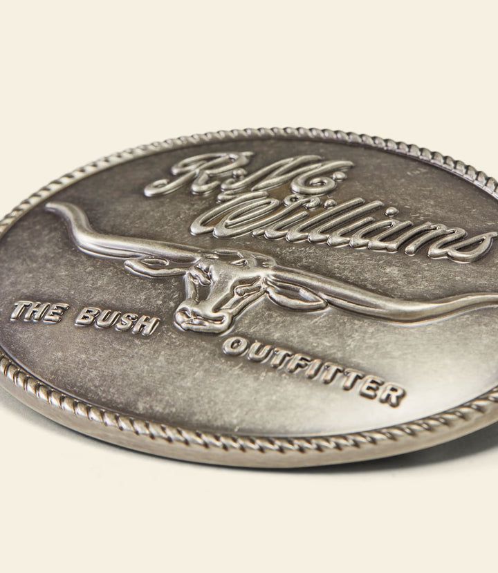 Close-up of silver circular buckle with RM Williams logo and The Bush Outfitter text