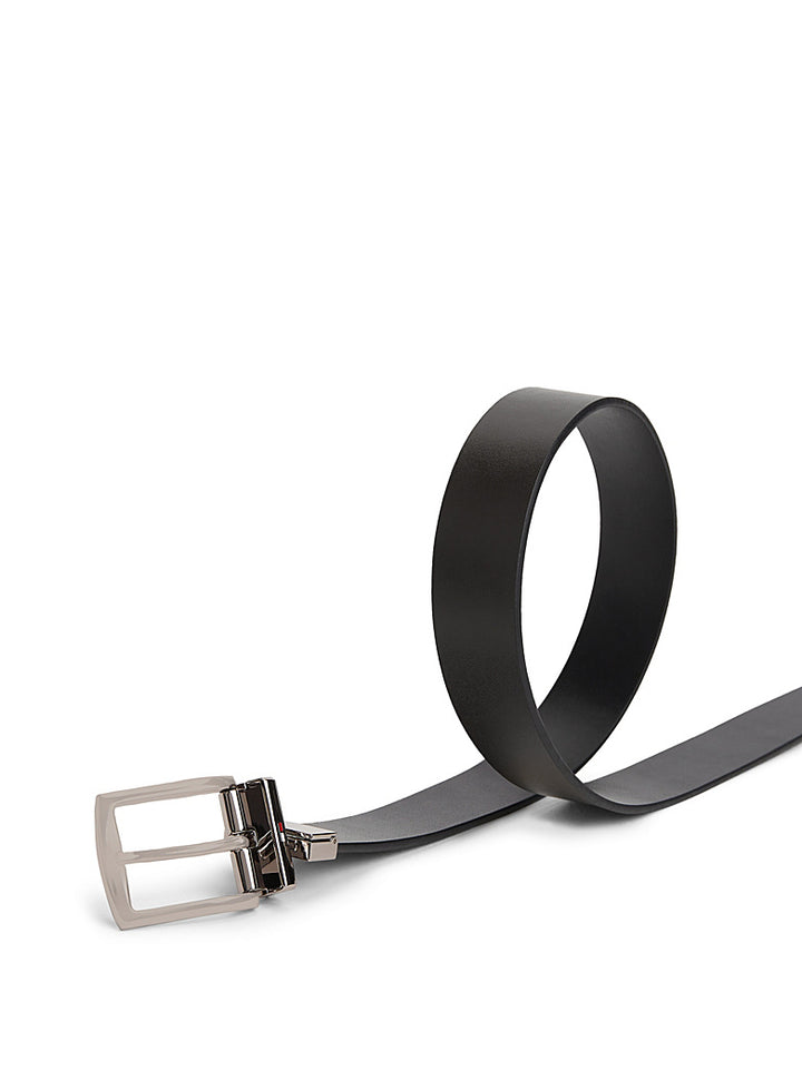 Reversible leather belt with silver buckle and black strap, end and loop view