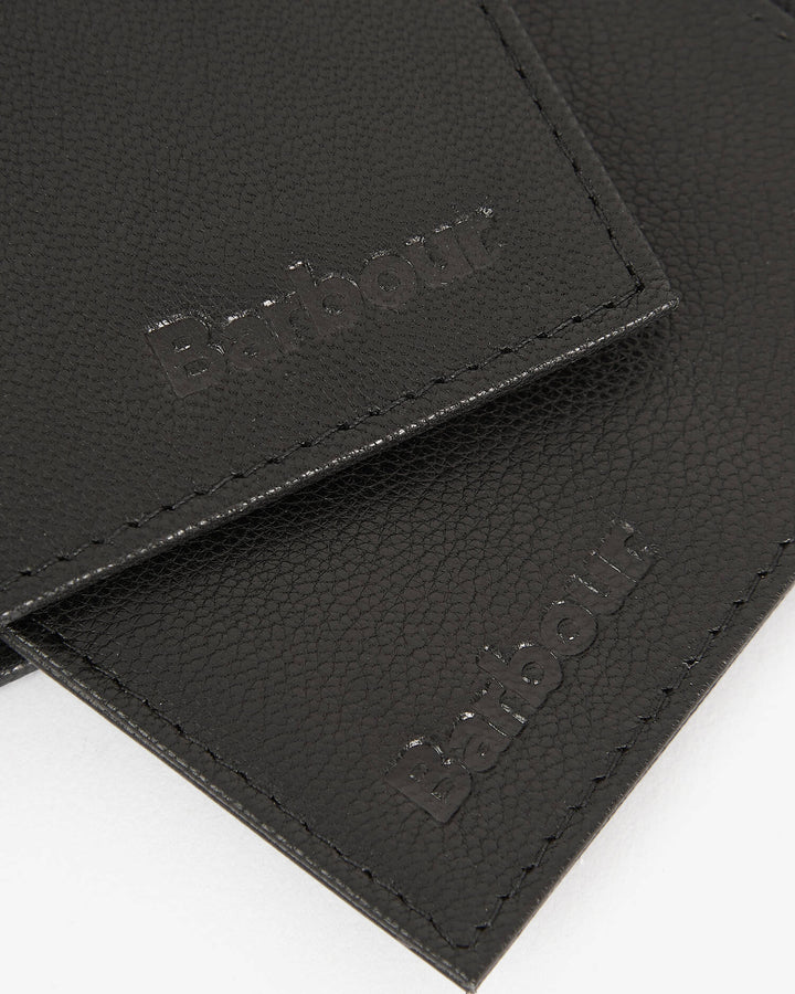 Black leather card holder close-up with stitched logo patch on flap