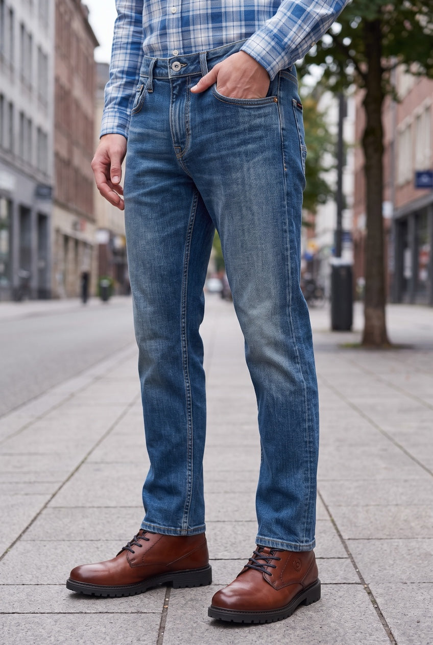 Slim-straight blue jeans on model, cuffed hem and visible side seams