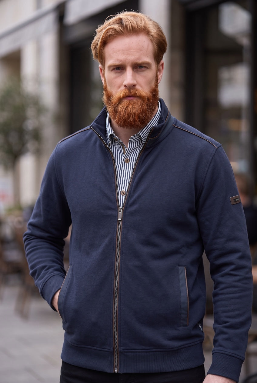 Navy full-zip sweatshirt worn by man, stand collar, striped shirt peeking at neck